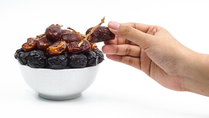 hand pick a dried date fruit from a bowl