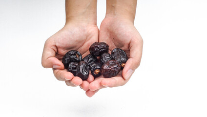 Dried dates fruit or Kurma hold by a hand on white background