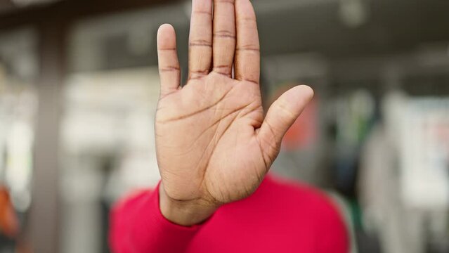 African american woman doing stop gesture with hand at street