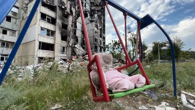 2022 - a playground with a teddy bear on swing and buildings are destroyed by Russian airstrikes in the Saltivka region of Kharkiv Ukraine.