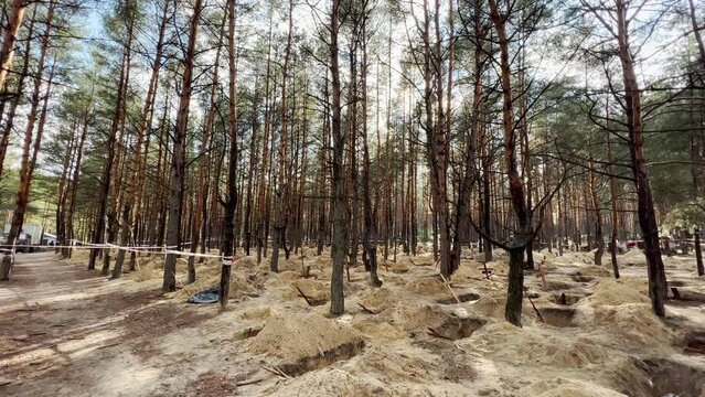 2022 - Mass graves suggest Russian war crimes and genocide in a forest in Izium, Ukraine following the regions liberation.