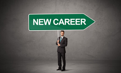 Young business person in casual holding road sign