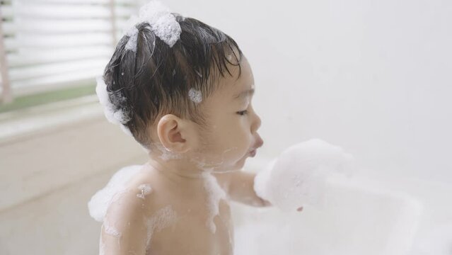 boy taking a bath in the tub take bath he plays with bubbles