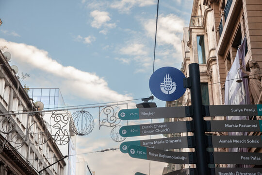 ISTANBUL, TURKEY - MAY 21, 2022: logo of Istanbul Buyuksehir Belediyesi, the Istanbul Metropolitan Municipality and administration, in front of signs indicating the main attractions of the European si
