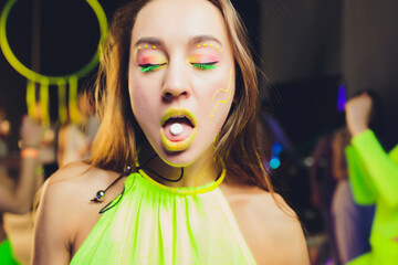 beautiful girl with lsd on tongue in nightclub with pink smoke.