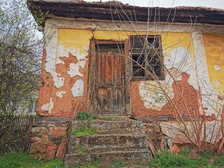 an old abandoned house, made of mud, clay, wood and stone. building from natural materials
