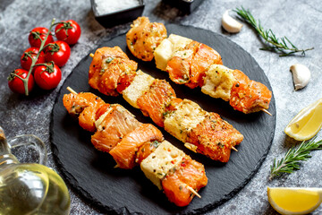 raw salmon skewers on skewers on a stone background.Raw seafood on skewers