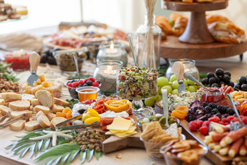 Elaborate charcuterie table set up with meats, bread, cheese, nuts, and fruit.