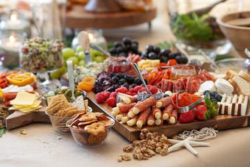 Elaborate charcuterie table set up with meats, bread, cheese, nuts, and fruit.