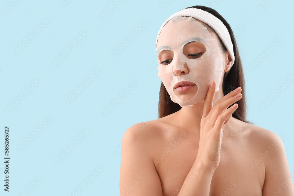 Sticker Young woman with sheet mask on blue background, closeup