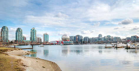 Touristic waterfront city panorama on a sunny spring day with modern highrise buildings, anchored...