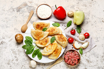 Composition with tasty meat empanadas and ingredients on grunge background