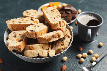 Delicious biscotti cookies, nuts, cup of coffee and chocolate on grunge background