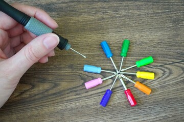 色んな種類の小さいscrewdriverとscrewdriverを持つ手/DIY