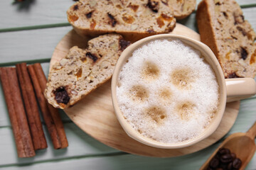 Delicious biscotti cookies and cup of coffee on green wooden background