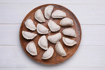 Raw dumplings (varenyky) on white wooden table, top view