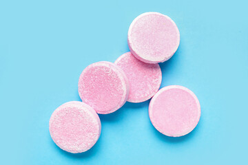 Obraz na płótnie Canvas Pink soluble tablets on blue background