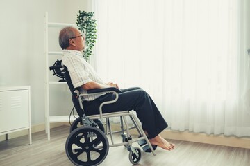 Portrait of an elderly man in a wheelchair alone with himself at home but contented with his lot in life. Convalescent facility for the crippled elderly in a nursing home. - obrazy, fototapety, plakaty