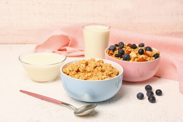 Bowls with tasty granola on light background