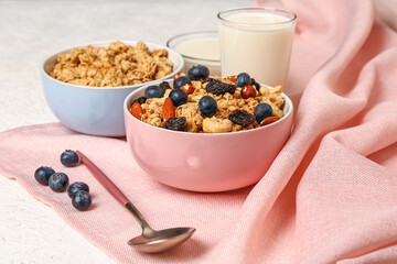 Bowls with tasty granola on light background