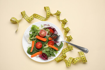 Measuring tape, vegetable salad and fork on beige background, flat lay. Weight loss concept