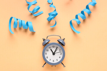 Composition with alarm clock and serpentine on color background