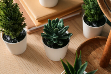 Artificial plants on wooden table, closeup