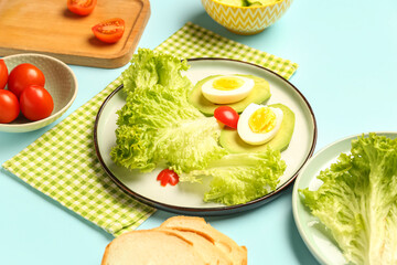 Plate with funny breakfast in shape of owl and ingredients on blue background, closeup