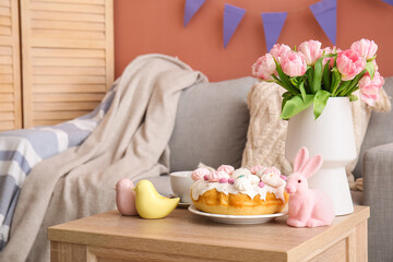 Easter cake, bunny, porcelain quails and vase with tulip flowers on table in living room