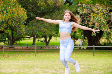 公園で楽しそうにジャンプするオーストラリアの女の子