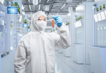 Worker wears medical protective suit or coverall suit with test tube in laboratory