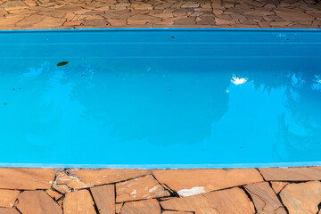 Detail of blue swimming pool and stone floor in Brazil