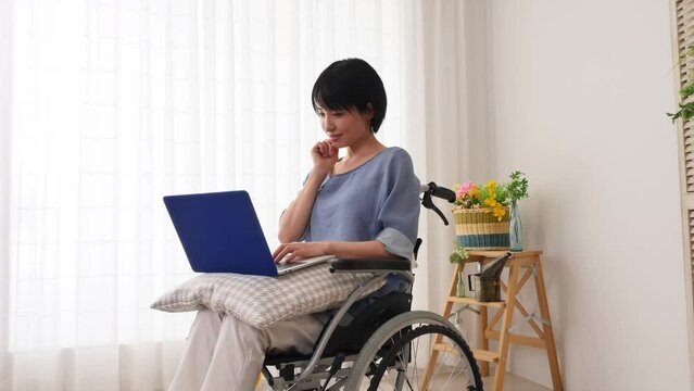 ビングでノートパソコンを使いながら想像する車椅子に乗った女性