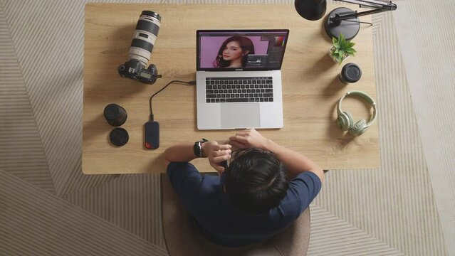 Top View Of A Male Editor Celebrating Succeed Using Using A Laptop Next To The Camera Editing Photo Of A Female In The Workspace At Home
