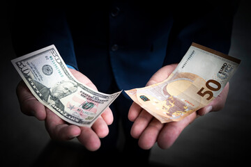 concept of choosing between the dollar and the euro. Banknotes of 50 euros and fifty dollars in the...