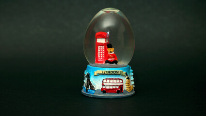 This snow globe, featuring the iconic landmarks of London, has a black background that provides a...