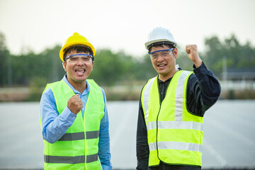 Asian engineer and technician on a solar power plant with success gesture.