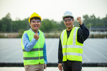 Fototapeta na wymiar Asian engineer and technician on a solar power plant with success gesture.
