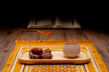 Many Date Palms are on bowls and cups of water and the Quran is on wooden tables, to wait for the time of Iftar, with the concept of ramadan Muslims around the world.