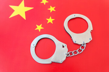 China flag and police handcuffs. The concept of observance of the law in the country and protection...