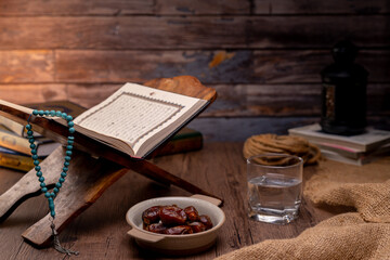 Many Date Palms are on bowls and cups of water and the Quran is on wooden tables, to wait for the time of Iftar, with the concept of ramadan Muslims around the world.