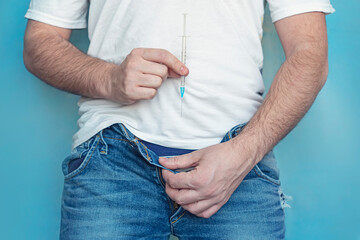 protection of sexually transmitted infections. a man holds a syringe in his hands and takes off his...