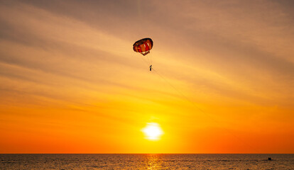 Silhouette Travel people Parasailing over sea Against sky during sunset in golden hour of sunset or sunrise sky,Active and extreme recreation