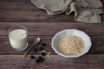 Oat flakes with blueberries and milk on wooden background
