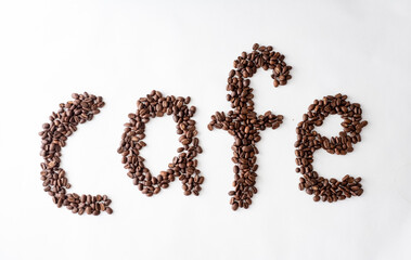 The word Cafe written in coffee beans on a white background