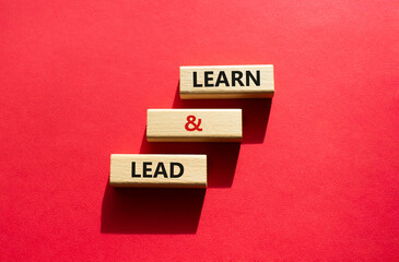 Learn and lead symbol. Concept words Learn and lead on wooden blocks. Beautiful red background. Business and Learn and lead concept. Copy space.