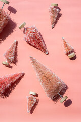 Miniature artificial Christmas trees, bottle brush trees for winter decor. Monochrome Christmas or New Year layout.