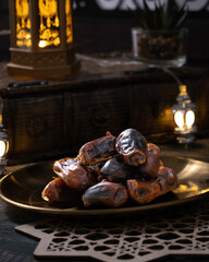 Ajwa dates on a golden plate on the table.  One of sunnah food for breakfasting Ramadhan 