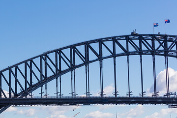 View of the famous Sydney Harbour Bridge in NSW Australia, with a group of bridge climbers visible on the top left.