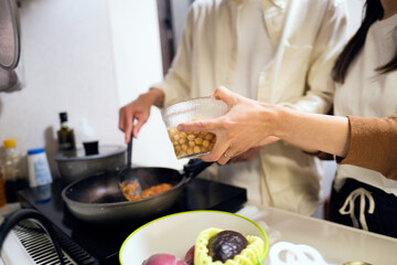 ヴィーガンカレーを作るカップルの手元のアップ